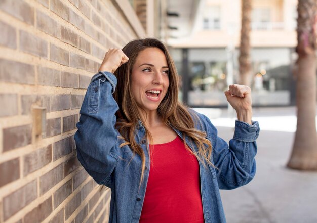 bella donna che si sente felice, positiva e di successo, che celebra i risultati della vittoria o la buona fortuna