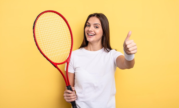 Bella donna che si sente orgogliosa, sorride positivamente con i pollici in su. concetto di giocatore di tennis