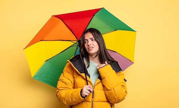 Bella donna che si sente stressata, ansiosa, stanca e frustrata. concetto di inverno e ombrello