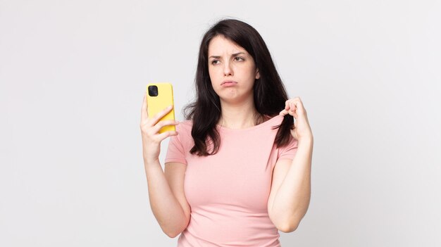 Bella donna che si sente stressata, ansiosa, stanca e frustrata usando uno smartphone