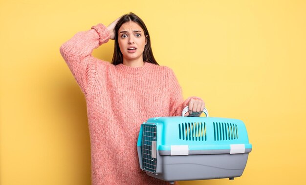 Bella donna che si sente stressata o spaventata con le mani sul concetto di trasportino per animali domestici