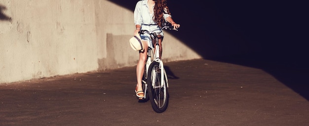 Bella donna che si siede sulla bicicletta della città