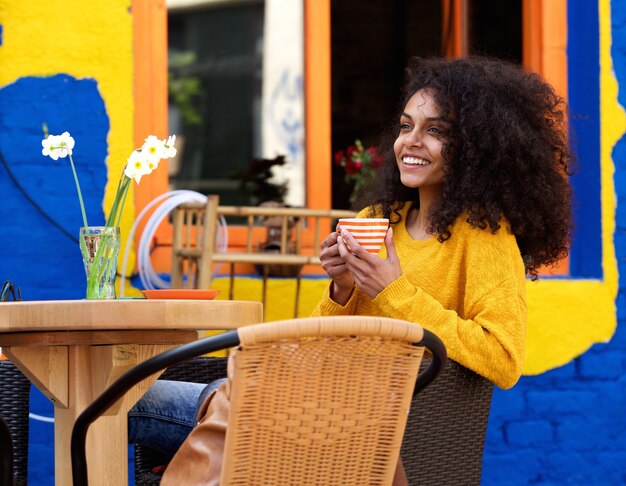 Bella donna che sorride con la tazza di caffè