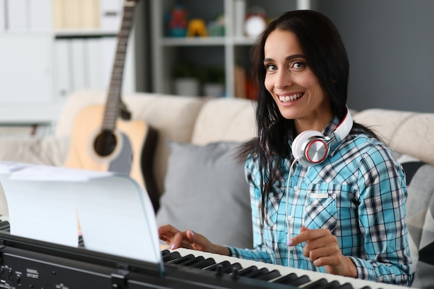 Bella donna che suona il pianoforte su sfondo