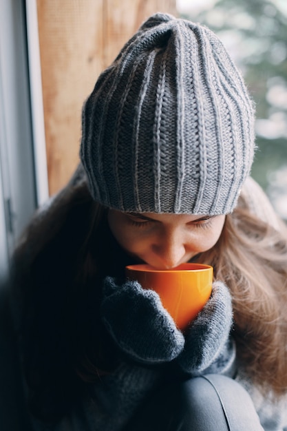 Bella donna che tiene e che beve una tazza di caffè