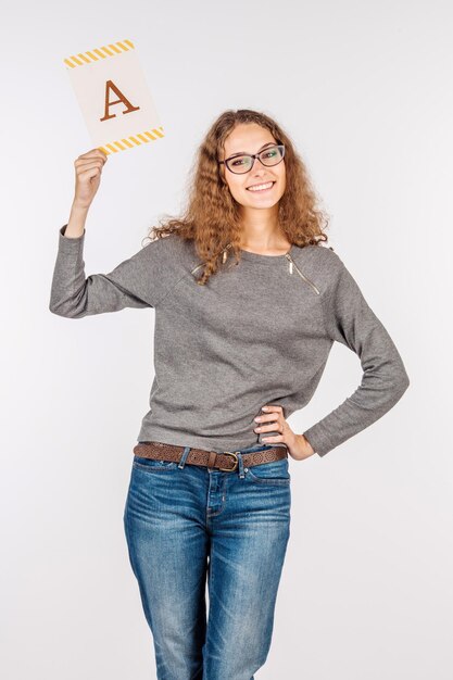 Bella donna che tiene un libro bianco in bianco con la lettera A