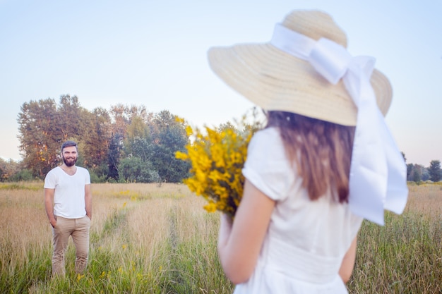 Bella donna che tiene un mazzo di fiori gialli e guarda