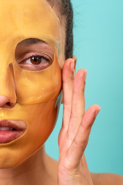 Bella donna che utilizza il trattamento della maschera per la cura della pelle del gel di collagene facciale