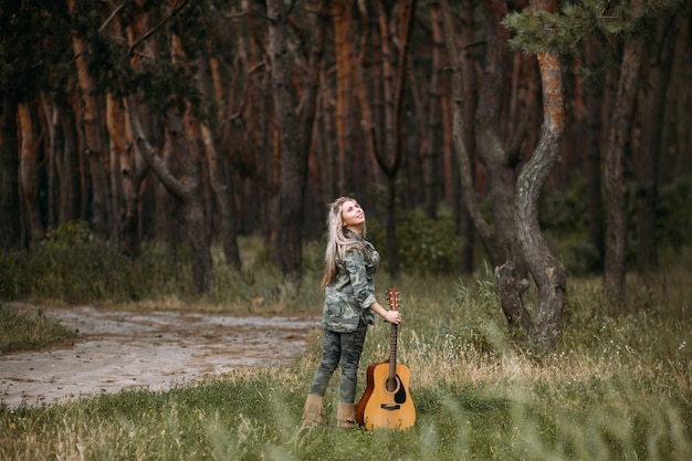 Bella donna chitarra natura fashion look concept. Unità con la natura. Musica nel cuore.