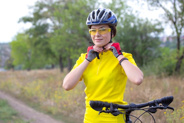 Bella donna ciclista con una bicicletta sulla natura. Stile di vita sano e sport. Tempo libero e hobby