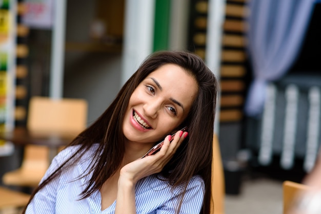 Bella donna comunica al telefono in strada.