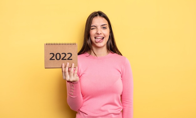 Bella donna con atteggiamento allegro e ribelle che scherza e tira fuori il concetto di calendario 2022