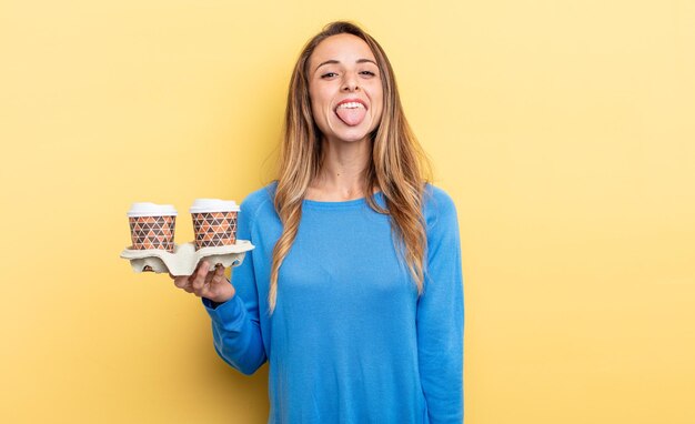 Bella donna con atteggiamento allegro e ribelle, scherzando e tirando fuori la lingua. portare via il concetto di caffè