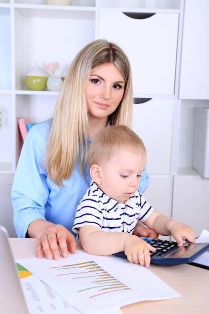 Bella donna con bambino che lavora a casa