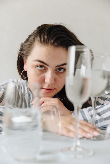 Bella donna con bicchieri d'acqua sul tavolo