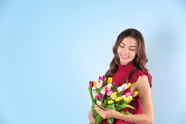 Bella donna con bouquet di tulipani su sfondo colorato