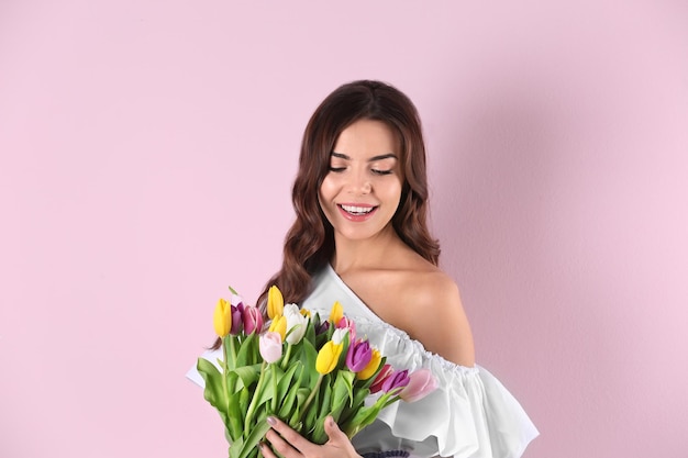 Bella donna con bouquet di tulipani su sfondo colorato