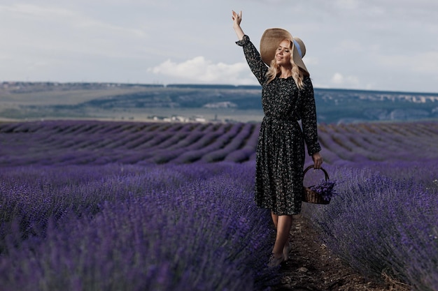 bella donna con cappello nel campo di lavanda