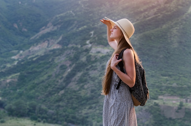 Bella donna con cappello sulla natura e vedere in lontananza. Vista posteriore del ritratto