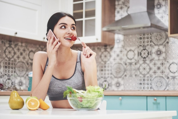 Bella donna con cibo sano frutta in cucina.