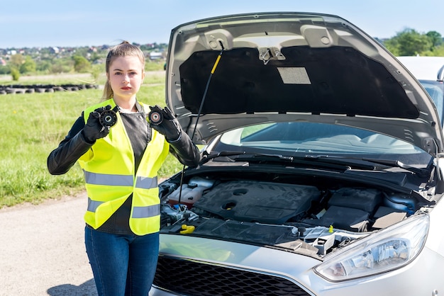 Bella donna con filtri per auto sul ciglio della strada