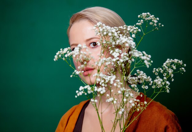 Bella donna con fiore di gypsophila sulla scena verde