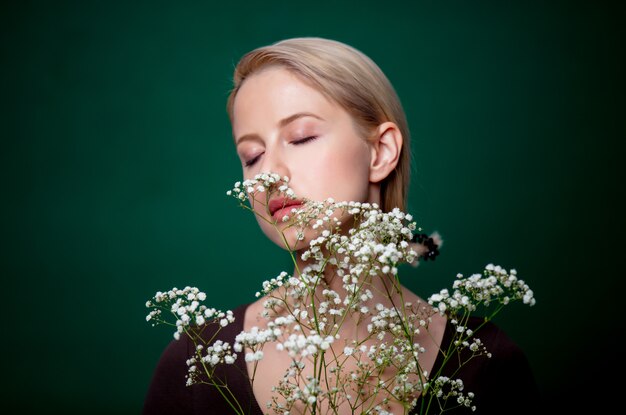 Bella donna con fiore di gypsophila sulla scena verde