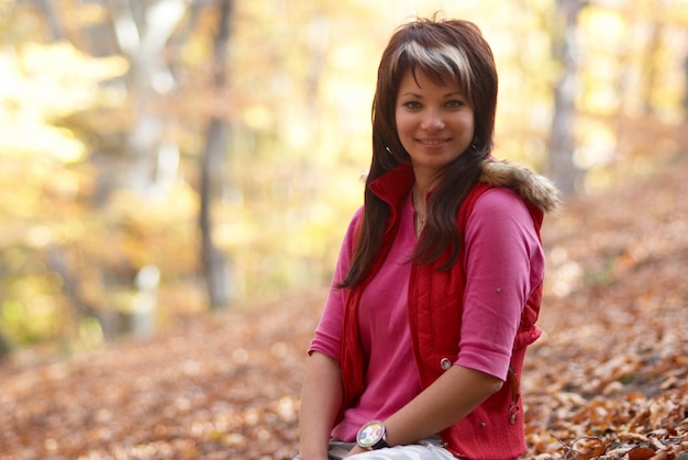 Bella donna con foglie che cadono nel parco autunnale