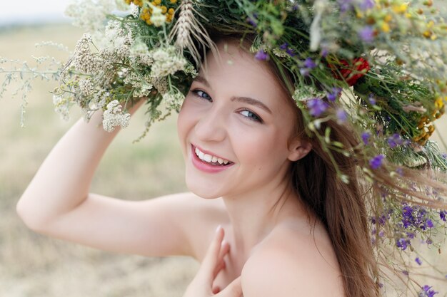 Bella donna con ghirlanda di fiori sulla testa.