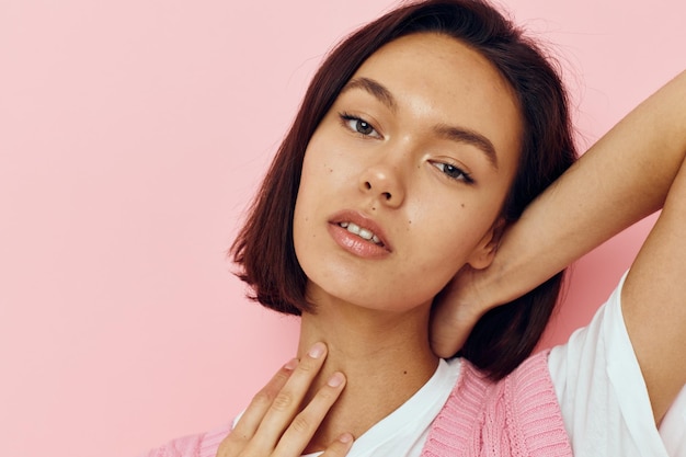 Bella donna con i capelli corti e un maglione rosa isolato sullo sfondo