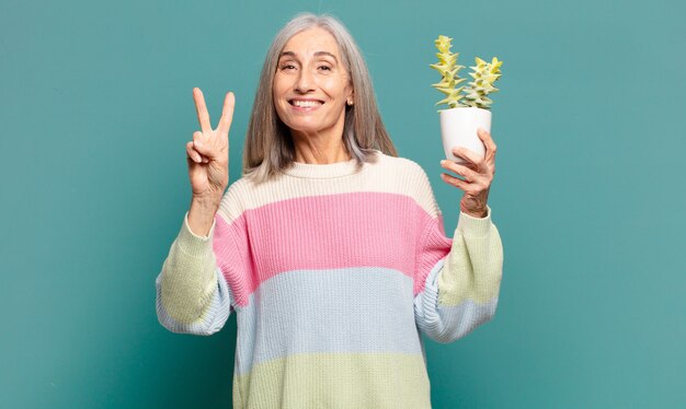 Bella donna con i capelli grigi con un cactus