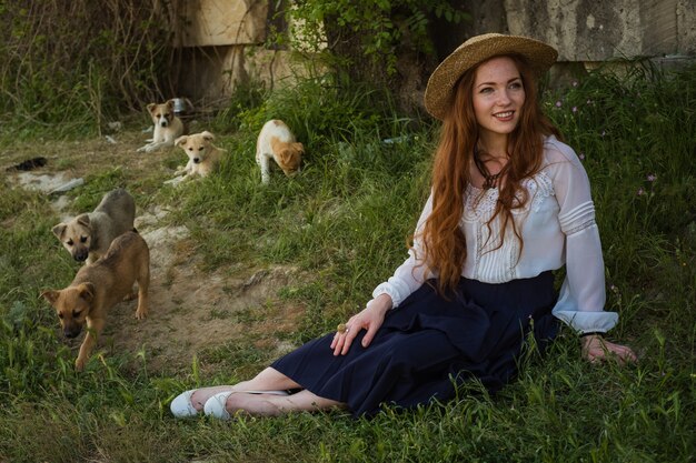 Bella donna con i capelli rossi in un cappello di paglia