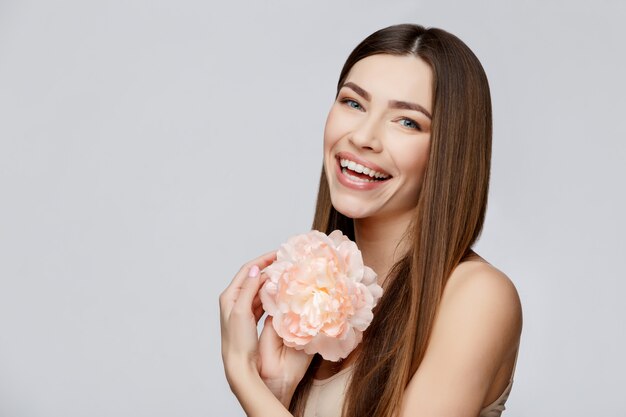 Bella donna con i fiori puliti della holding della pelle fresca