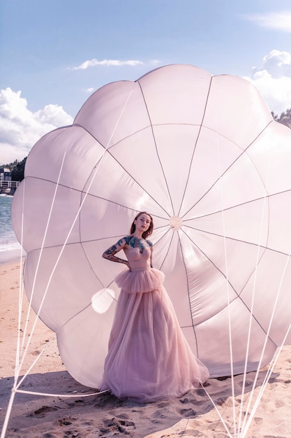 Bella donna con il paracadute bianco in spiaggia