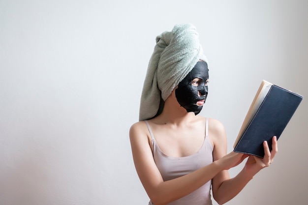 Bella donna con maschera facciale nera, concetto di stile di vita