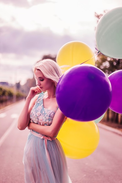 Bella donna con molti palloncini