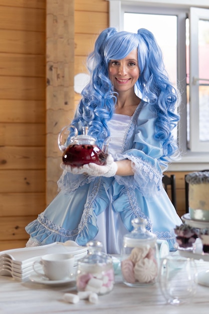 Bella donna con parrucca blu in un vestito in casa.