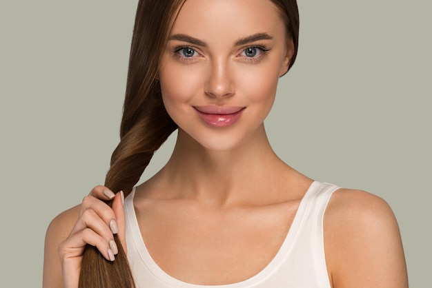 Bella donna con stile casuale di bellezza della coda dei capelli sani lunghi lisci. Colore di sfondo verde