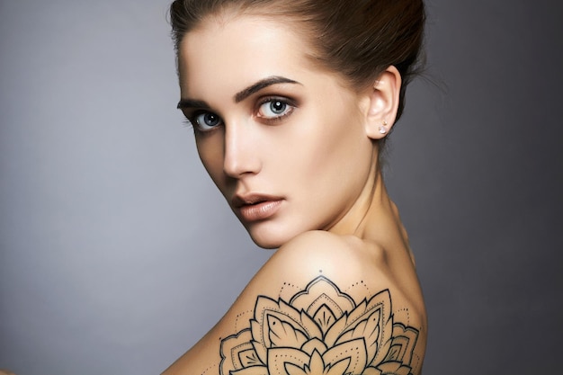 Bella donna con tatuaggio e trucco