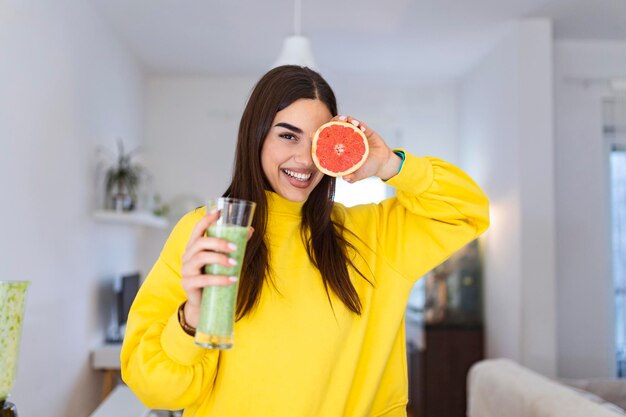 Bella donna con un bicchiere di frullato e pompelmo Stile di vita sano Dieta alimentare cruda Dieta vegetariana Nutrizione organica Pasto disintossicante