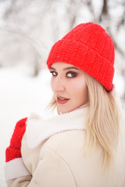 Bella donna con un cappello rosso in inverno