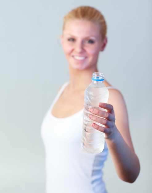 Bella donna con una bottiglia di acqua con focus sull&#39;acqua