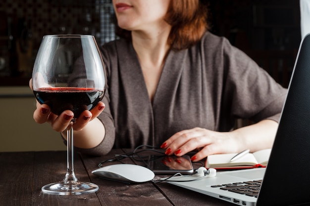 Bella donna con vino rosso di vetro