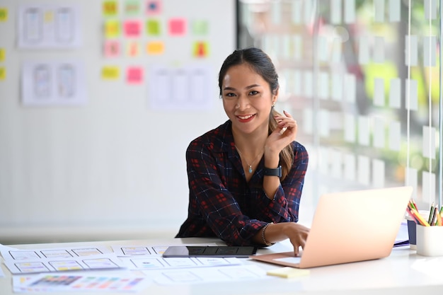 Bella donna creativa o sviluppatore che lavora alla progettazione dell'interfaccia utente in un ufficio moderno