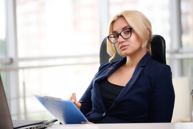 Bella donna d'affari che sogna mentre si lavora al computer nel suo ufficio