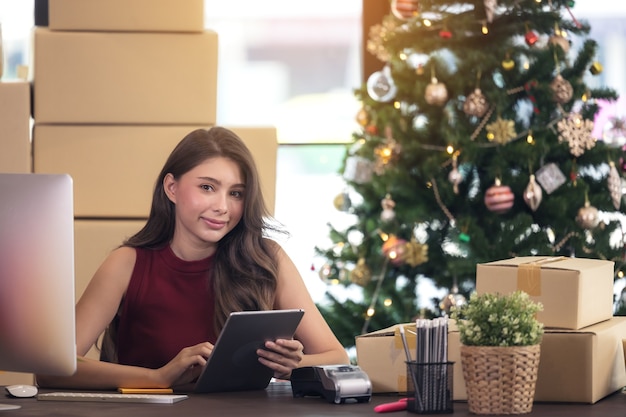 Bella donna d'affari con tablet seduto alla scrivania in ufficio.