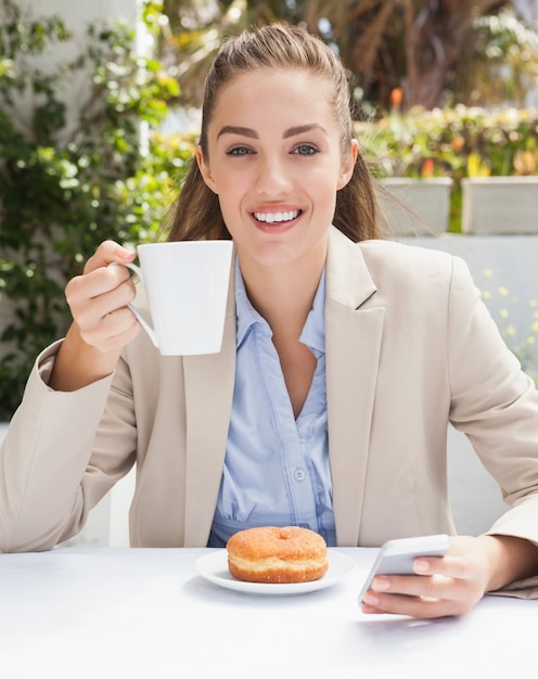 Bella donna d&#39;affari con un caffè e un muffin