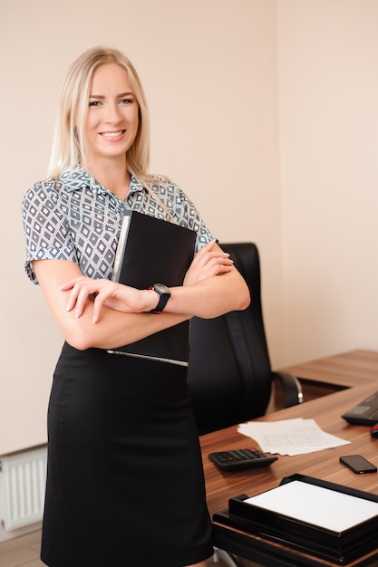 Bella donna d'affari felice lavorando con le vendite nel suo ufficio