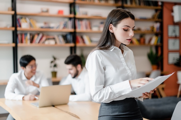 Bella donna d'affari in ufficio con gli impiegati