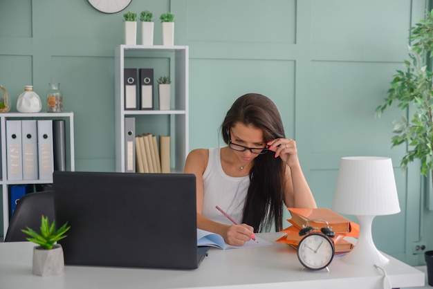 bella donna d'affari lavora in ufficio su un laptop freelance al lavoro insegna l'insegnante